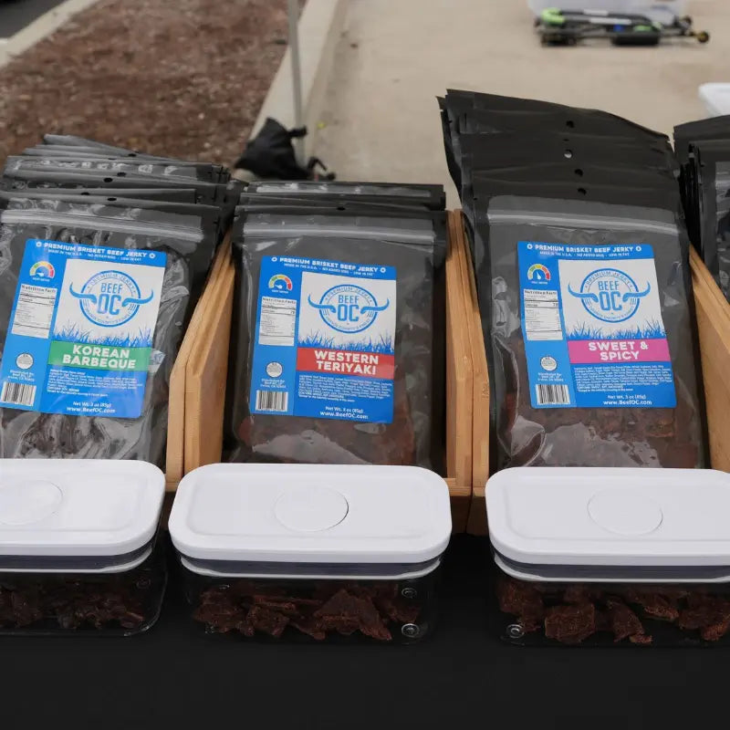 Biltong and beef jerky packages displayed on a booth at a farmers market